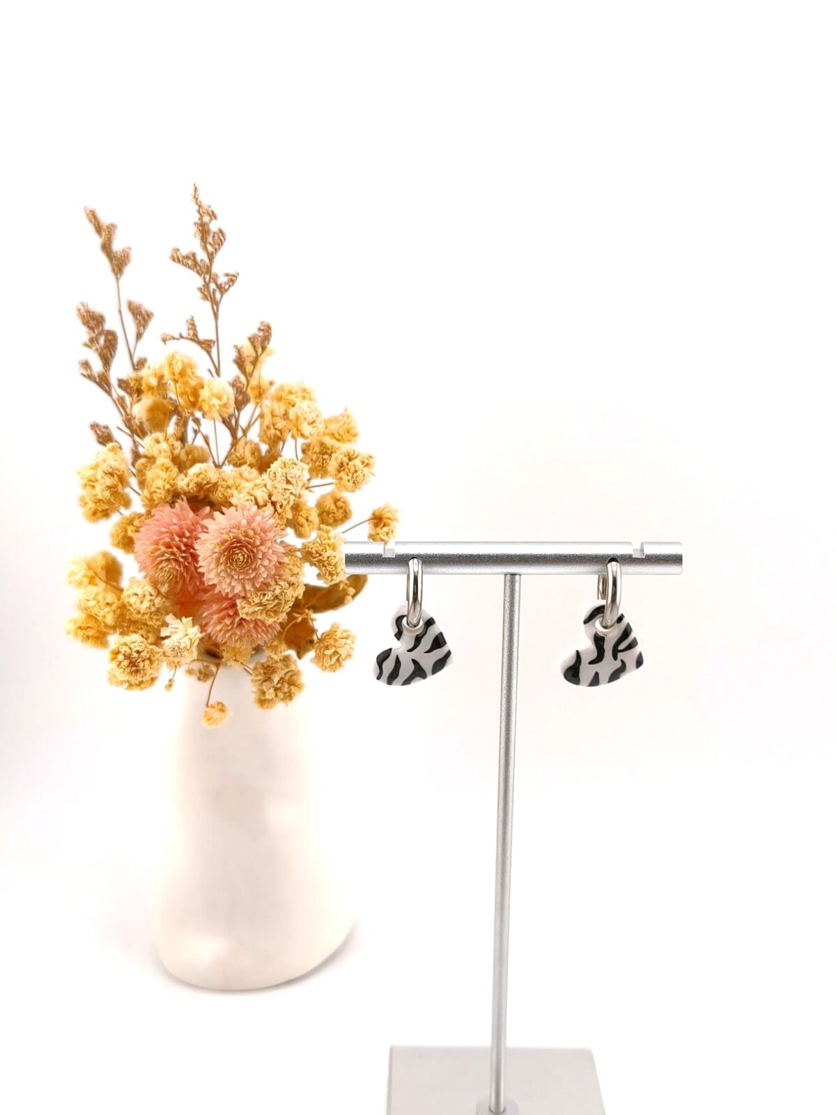 Brincos de argola com pendente em forma de coração com padrão zebra a preto e branco