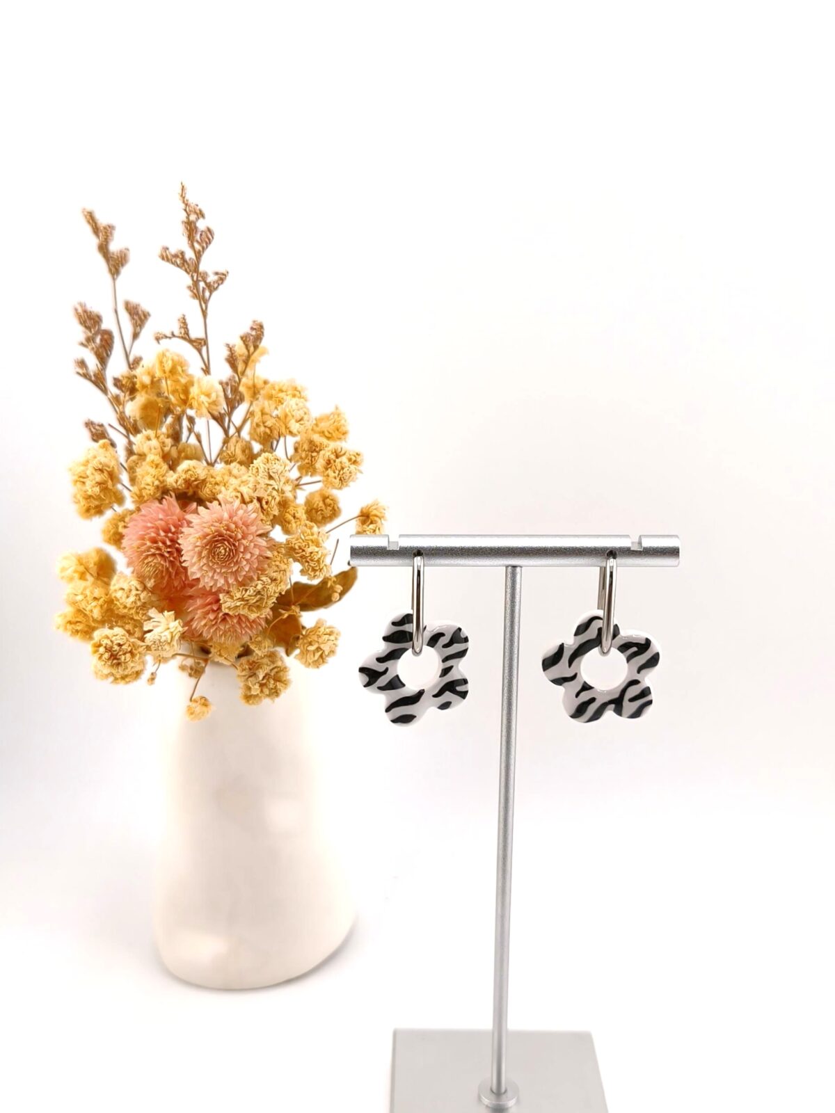 Brincos de argola com pendente em forma de flor com padrão zebra a preto e branco