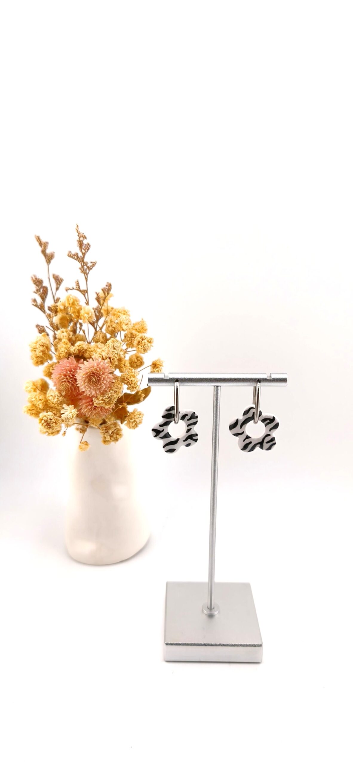 brincos argolas flor padrao zebra preto branco alma e vida Brincos de argola com pendente em forma de flor com padrão zebra a preto e branco