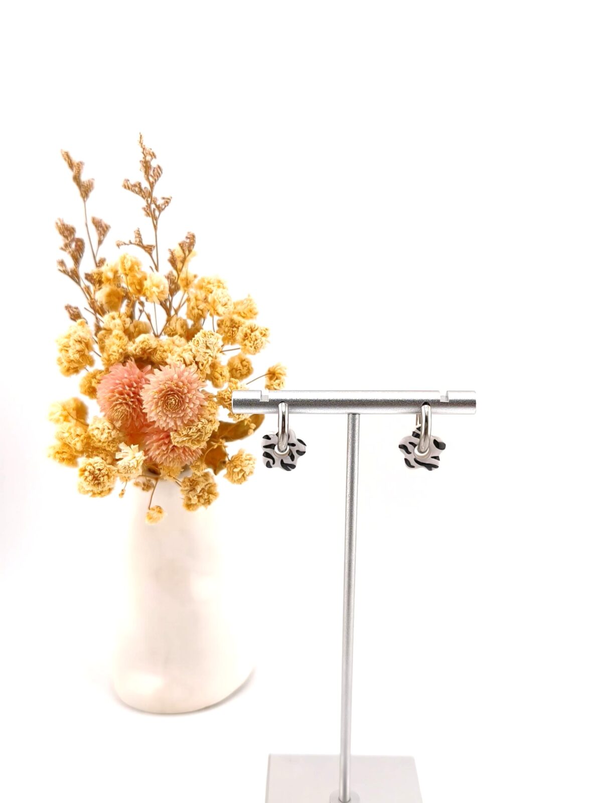 Brincos de argola com pendente em forma de flor com padrão zebra a preto e branco