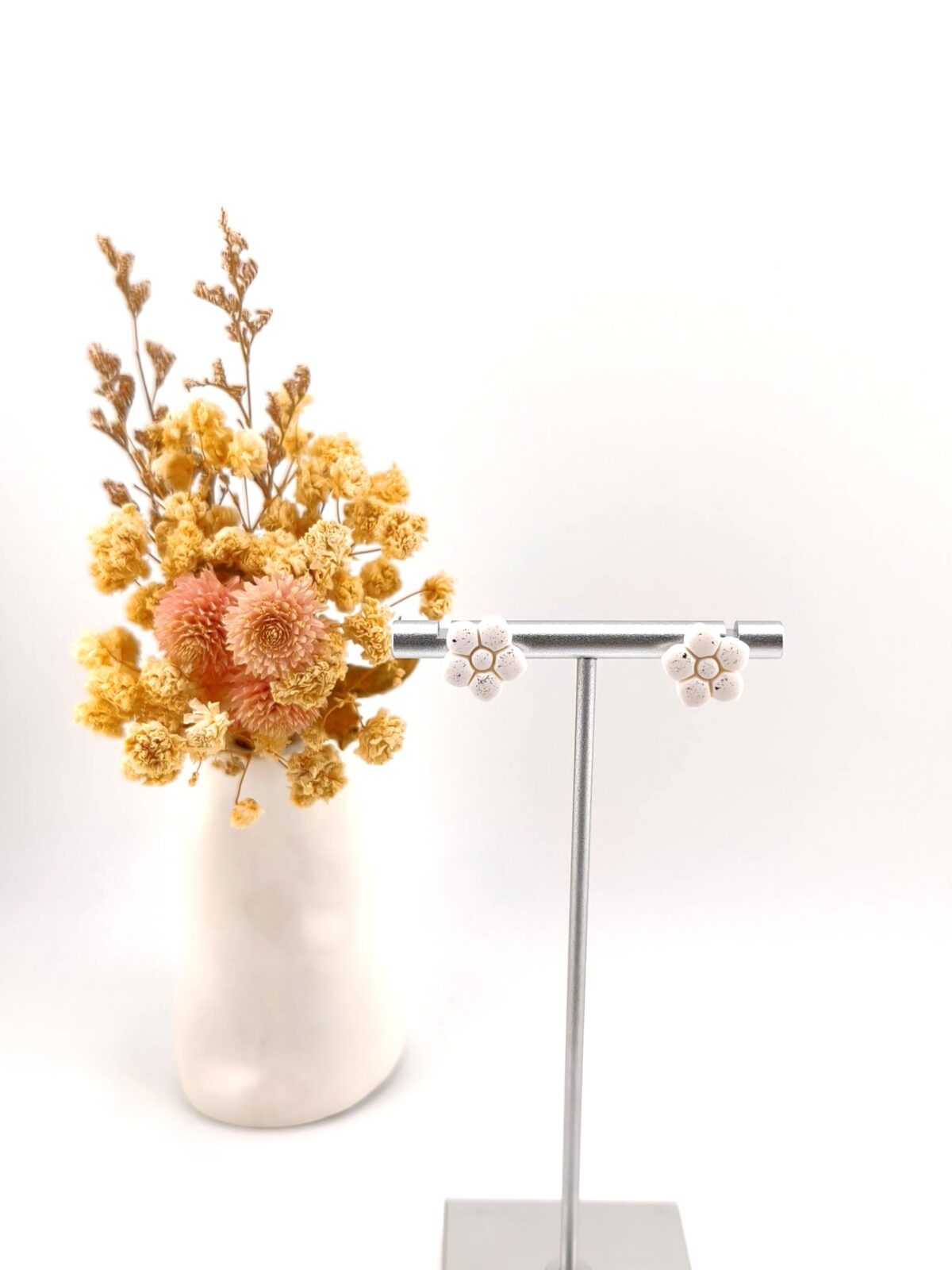 Brincos artesanais com pequenas flores brancas