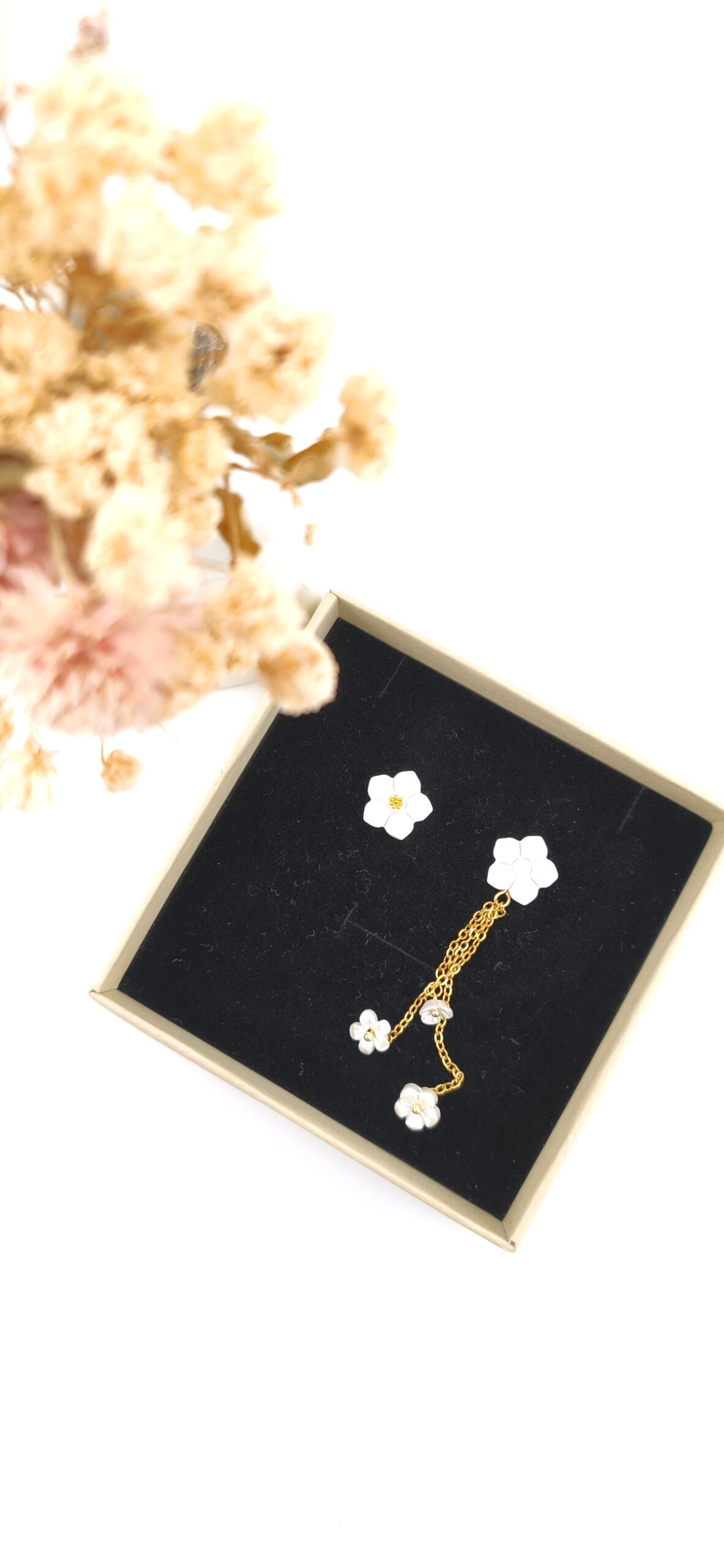 brincos desemparelhados flores brancas dourado alma e vida2 Brincos desemparelhados com flores brancas e detalhes dourados em expositor