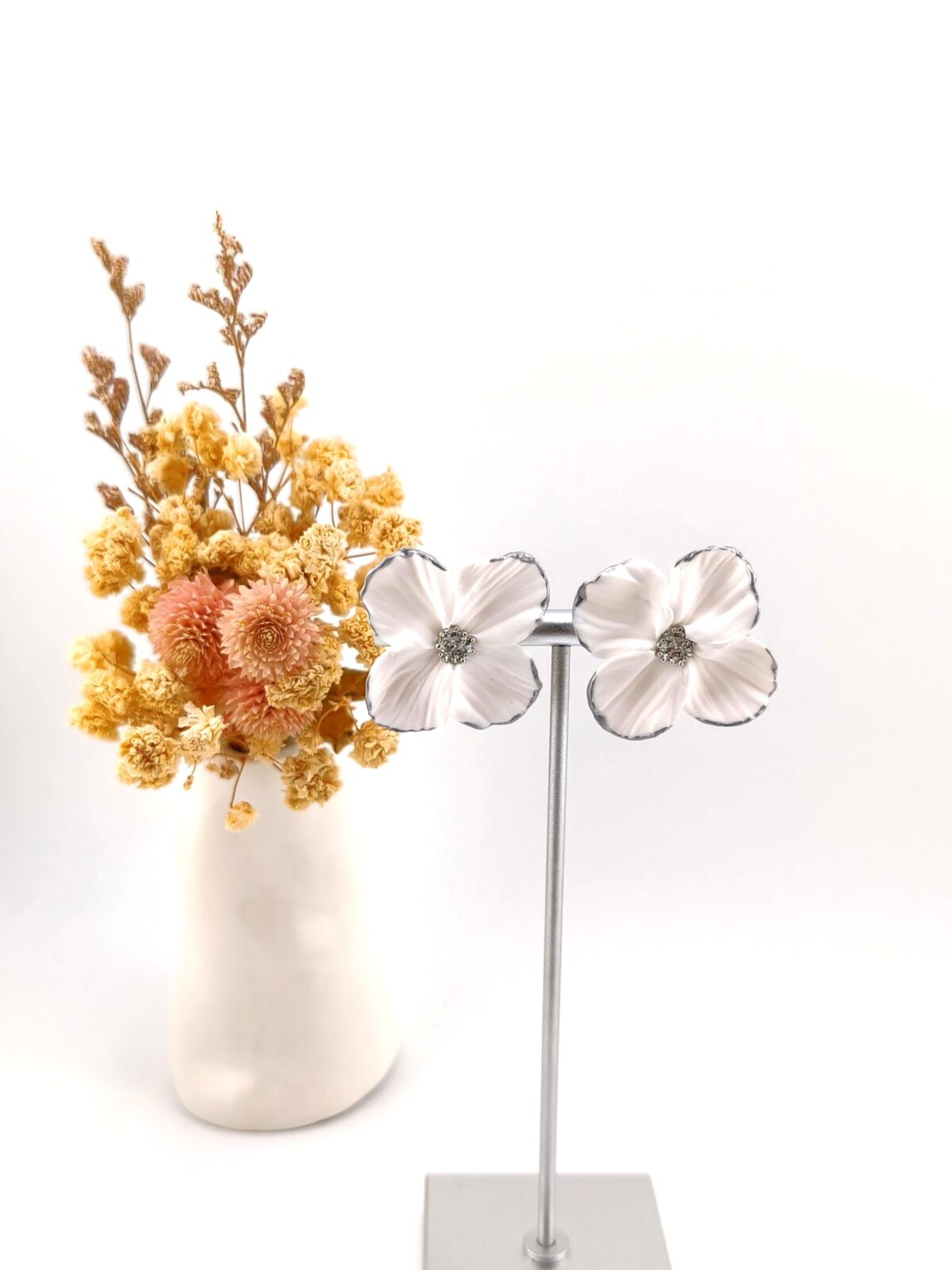 Brincos artesanais em forma de flor branca com contorno e centro prateados